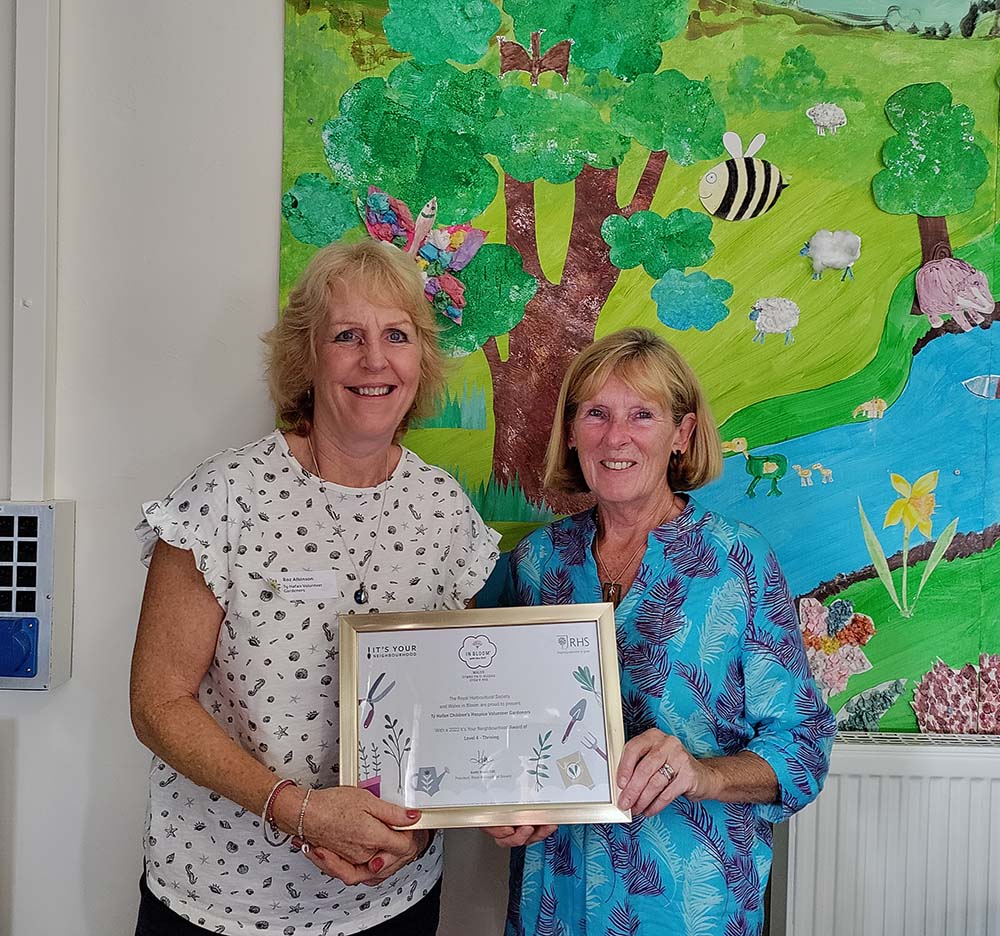 Volunteer gardeners holding their Wales in Bloom award