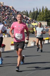 A photo of Robert mid race. He is wearing a pink/red running shirt