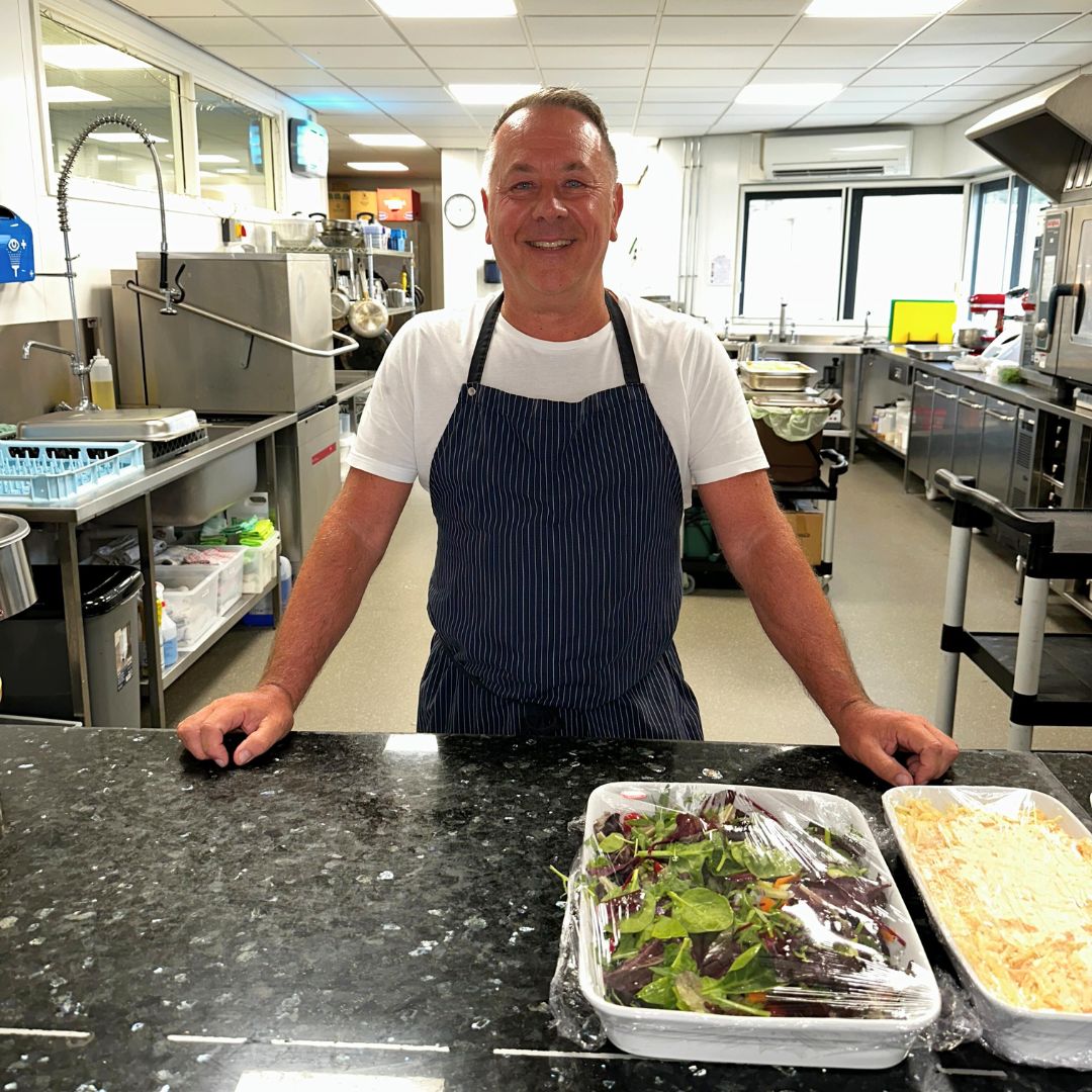 A photo of Paul in his chef's apron standing in the kitchens at Ty hafan