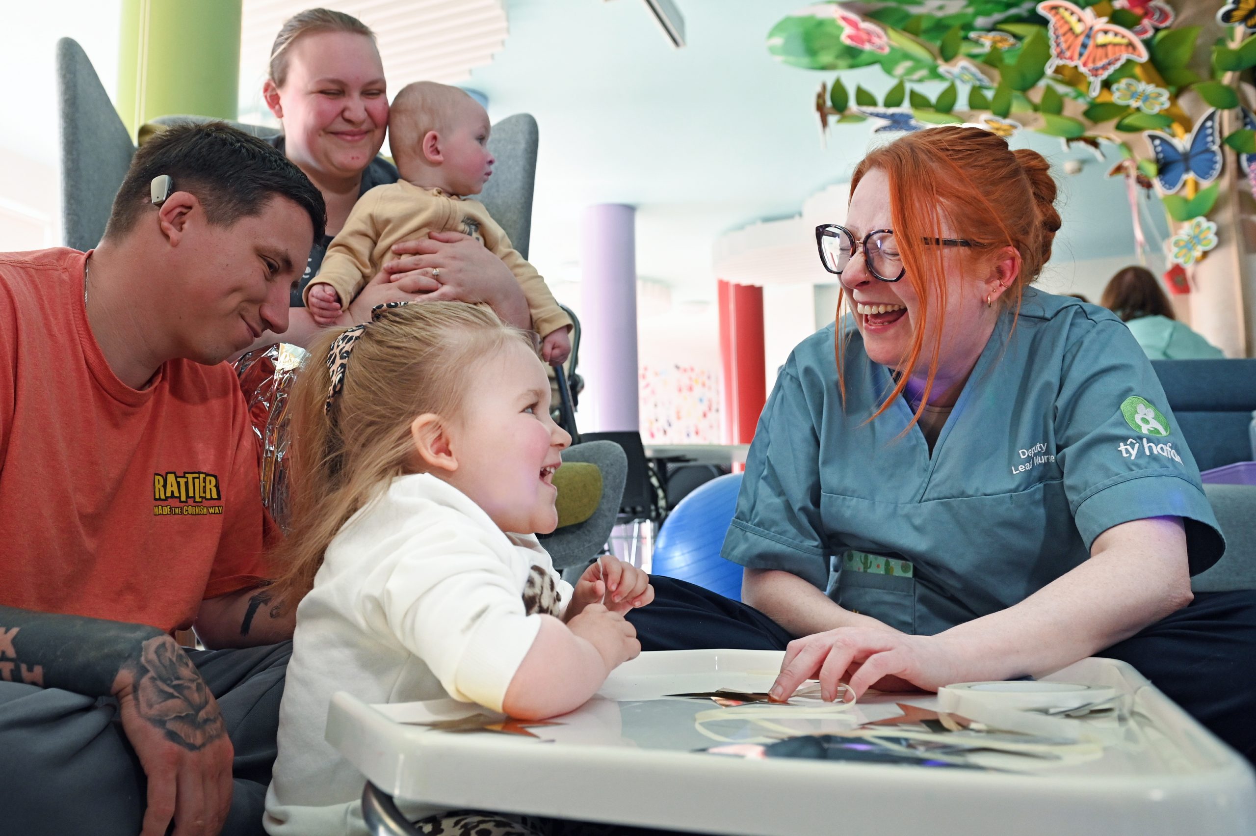 Tŷ Hafan nurse Carly and Dani-Rae enjoy a giggle together with Dani-Rae's dad Charlie, mum Tyler and little brother Tommy at Tŷ Hafan's hospice in Sully