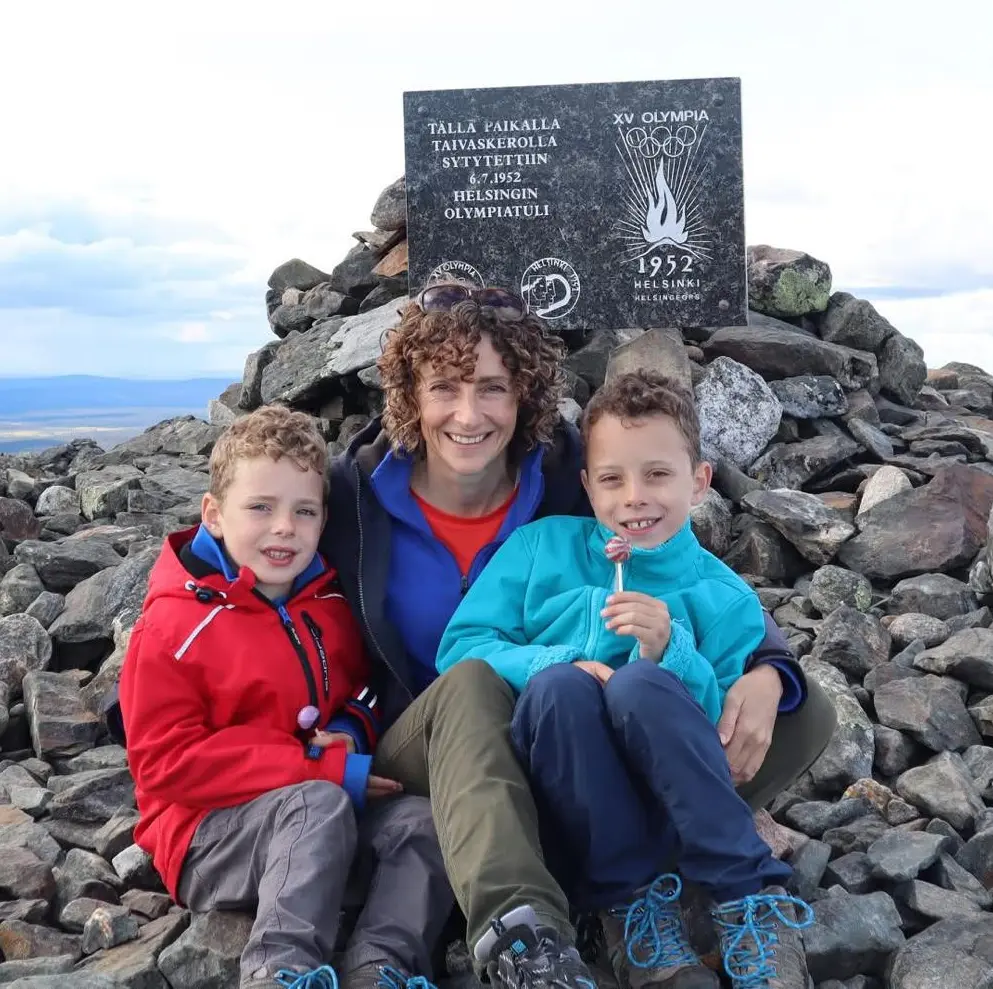 A photo of Theo, his younger brother Frank and mum Helen sitting at the top of a mountain