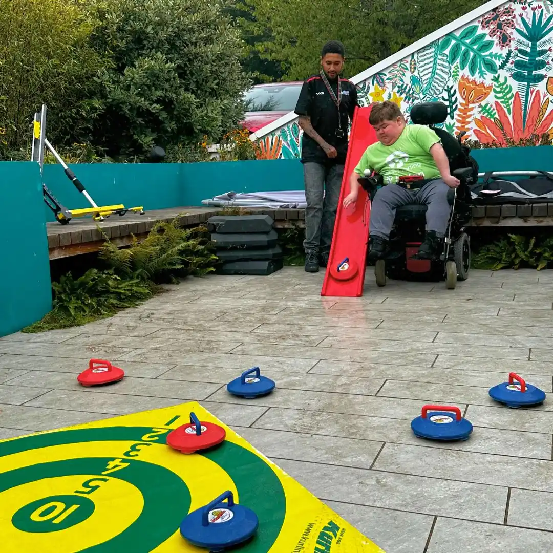 A photo of Seth from Youth Club taking part in Curling